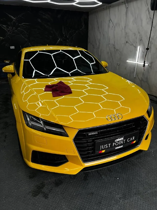 Жёлтая Audi TT в боксе студии перед выставкой